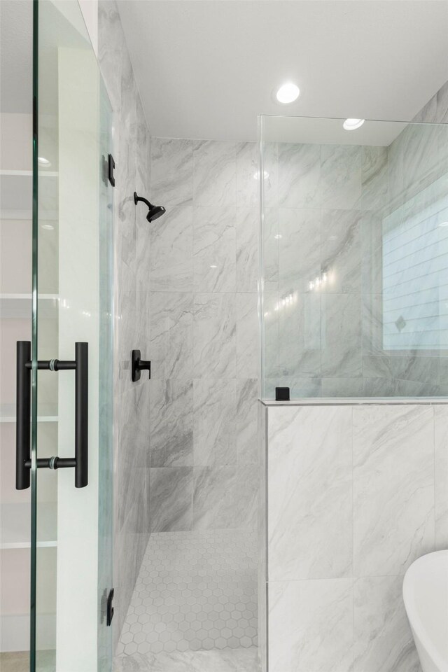 bathroom featuring a shower stall, a soaking tub, and recessed lighting