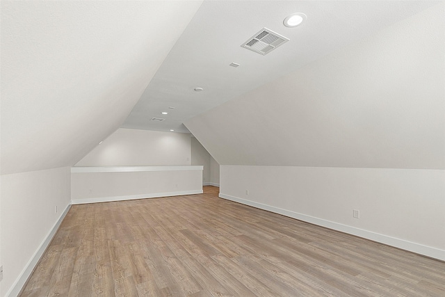 bonus room featuring light wood-style flooring, vaulted ceiling, baseboards, and recessed lighting
