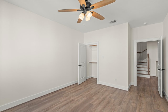 unfurnished bedroom featuring wood finished floors, baseboards, and a ceiling fan
