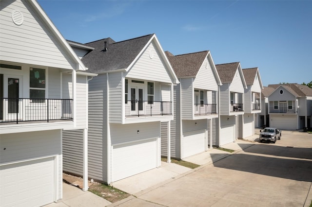 view of front facade with an attached garage, a residential view, and concrete driveway