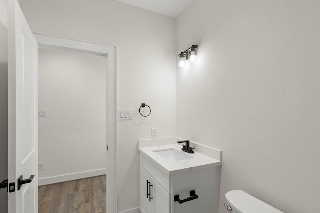 1807 Palmetto Landing Dr, Houston, TX 77009 - half bathroom featuring vanity, wood finished floors, toilet, and baseboards