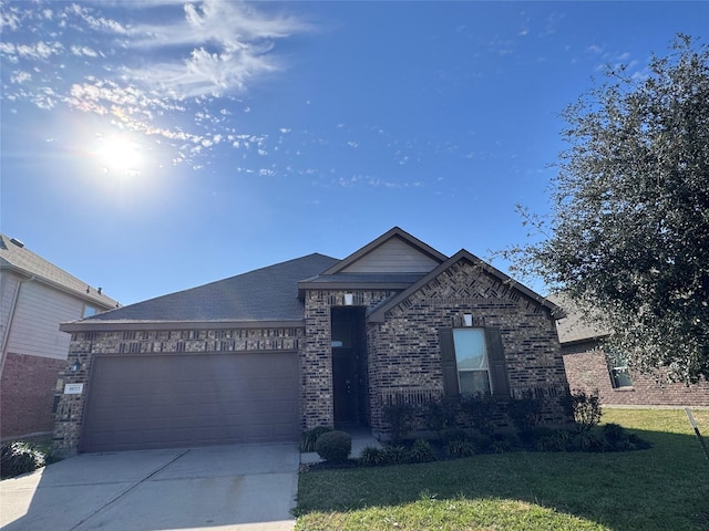 view of front of house with an attached garage, driveway, a front lawn, and brick siding