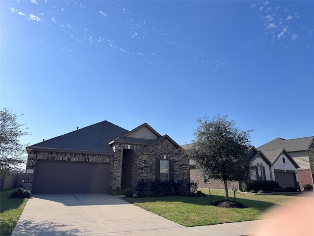 view of front of home featuring an attached garage, a front lawn, concrete driveway, and brick siding