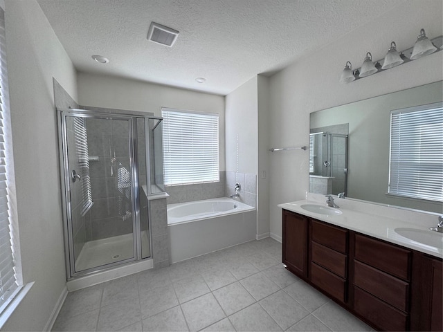 full bath featuring tile patterned flooring, a sink, a shower stall, and a bath