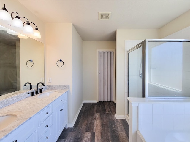 bathroom featuring a shower stall, visible vents, a sink, and wood finished floors