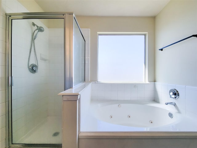 full bath featuring a shower stall and a tub with jets