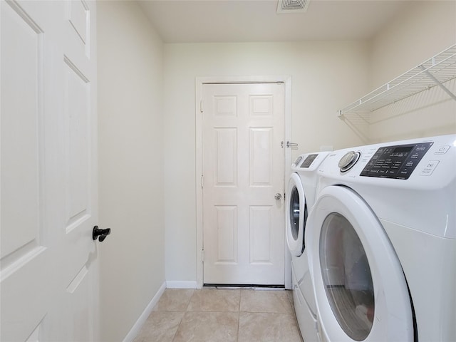 washroom with light tile patterned floors, visible vents, laundry area, independent washer and dryer, and baseboards