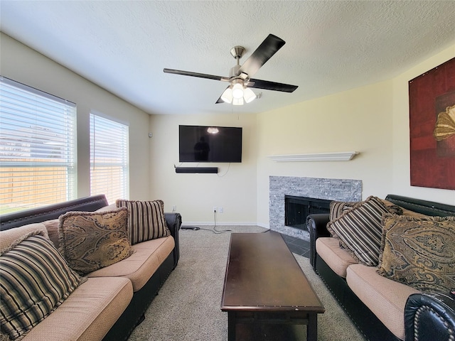 carpeted living room with a fireplace with flush hearth, ceiling fan, a textured ceiling, and baseboards