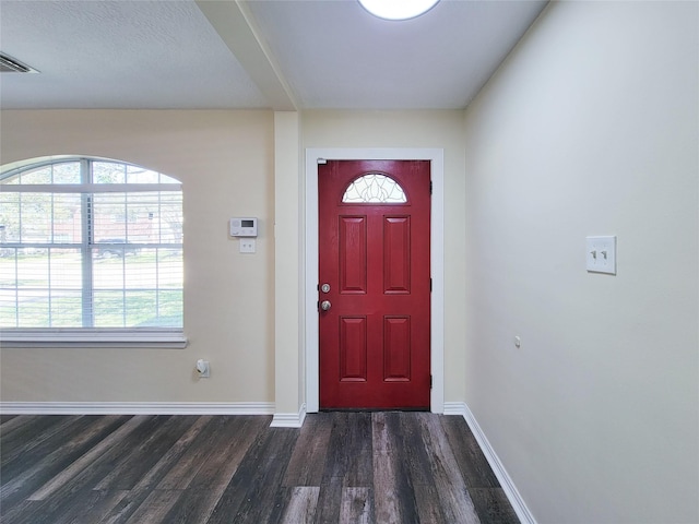 foyer featuring dark wood finished floors, visible vents, and baseboards