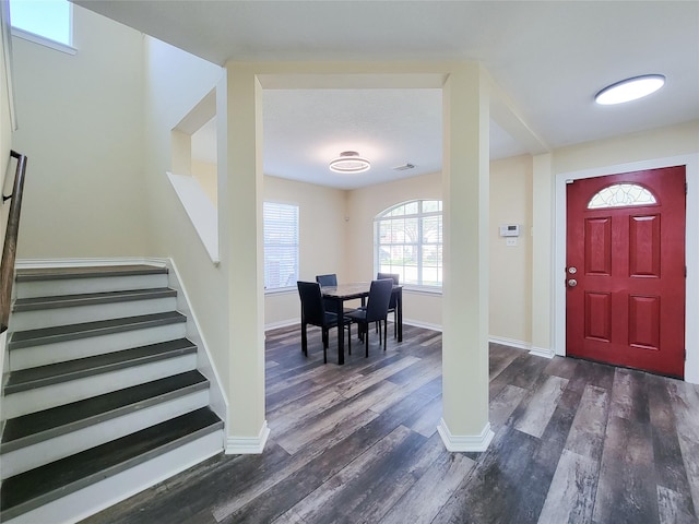 entrance foyer featuring dark wood-style floors, visible vents, stairs, and baseboards