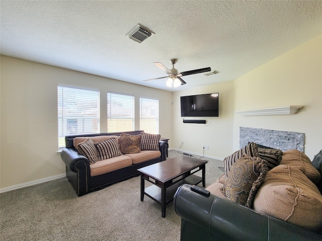 living area with a fireplace, carpet flooring, visible vents, and baseboards