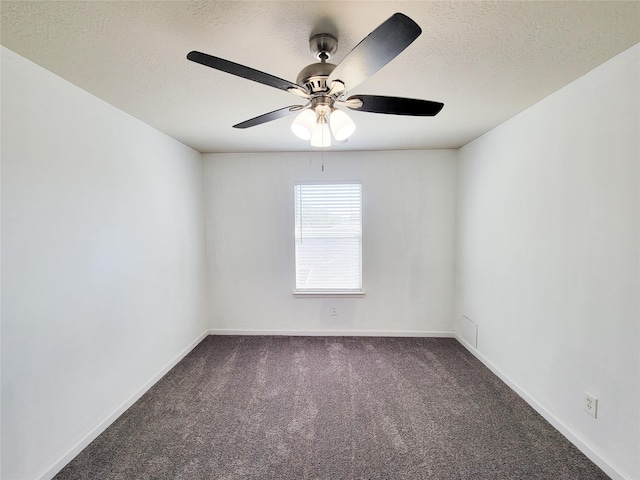 empty room with carpet flooring, a textured ceiling, and baseboards