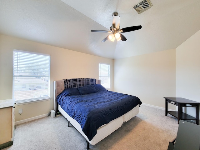 bedroom featuring light colored carpet, visible vents, vaulted ceiling, ceiling fan, and baseboards