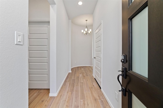 foyer featuring light wood-style floors, baseboards, a chandelier, and recessed lighting