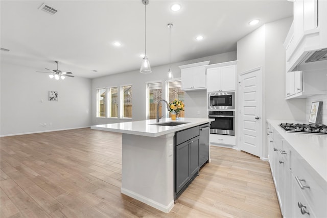 kitchen with visible vents, stainless steel appliances, a sink, and light countertops