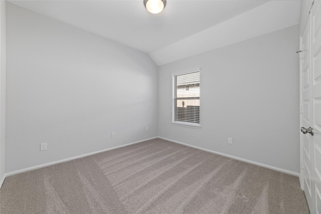 unfurnished room featuring lofted ceiling, baseboards, and carpet floors