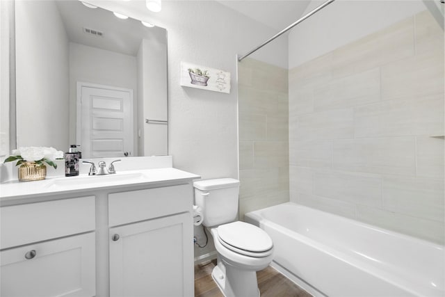 bathroom featuring bathtub / shower combination, visible vents, toilet, vanity, and wood finished floors