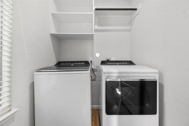 laundry room with laundry area, washer and clothes dryer, and wood finished floors