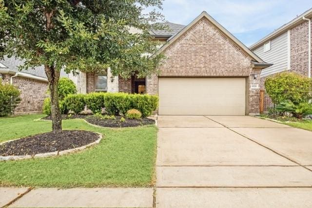 view of front facade with a garage, brick siding, and driveway