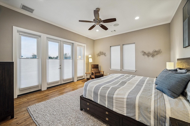 bedroom featuring access to exterior, visible vents, ornamental molding, and wood finished floors