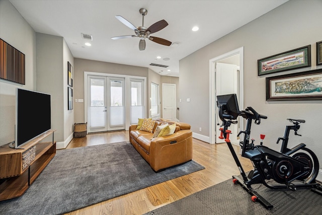 exercise area with light wood finished floors, baseboards, visible vents, and french doors