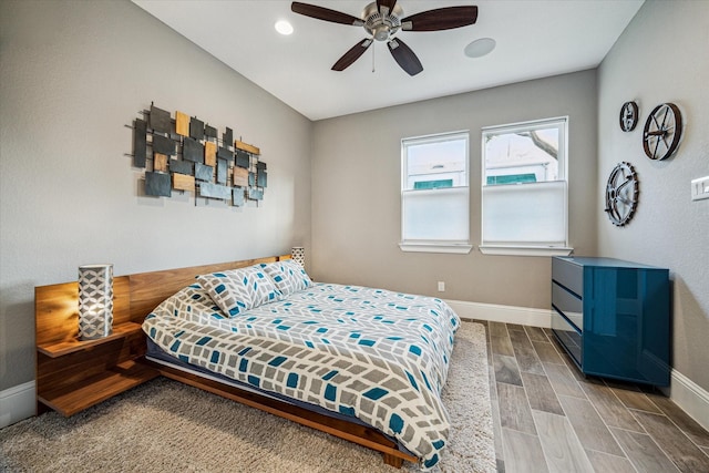 bedroom featuring a ceiling fan, wood tiled floor, and baseboards