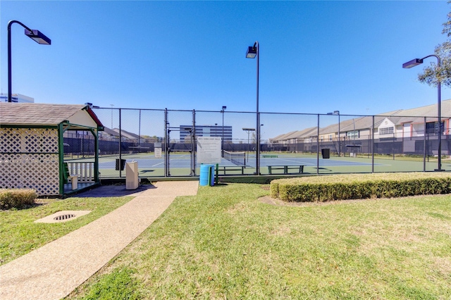 view of sport court featuring a yard, a gate, and fence