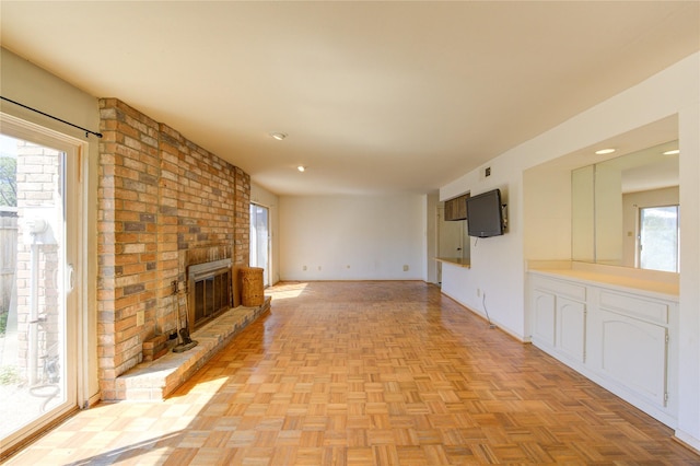 unfurnished living room with a fireplace, a wealth of natural light, and baseboards