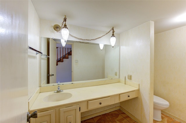 half bathroom featuring tile patterned flooring, vanity, and toilet