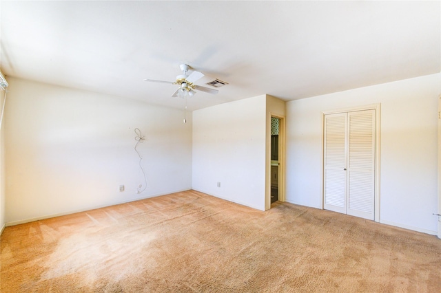 carpeted empty room with a ceiling fan and visible vents