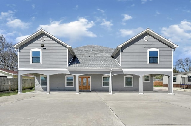 view of front of property featuring roof with shingles and fence