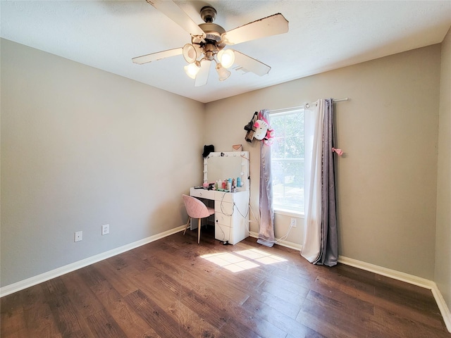 interior space with a ceiling fan, dark wood-style flooring, and baseboards