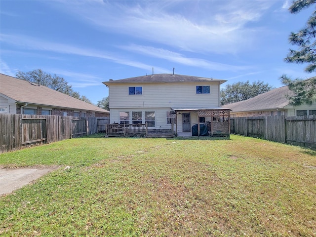 rear view of house featuring a fenced backyard, a deck, and a lawn