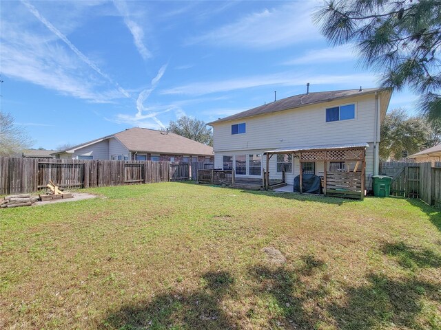 rear view of property featuring a fenced backyard and a lawn