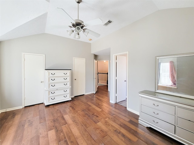 unfurnished bedroom with lofted ceiling, visible vents, a ceiling fan, wood finished floors, and baseboards