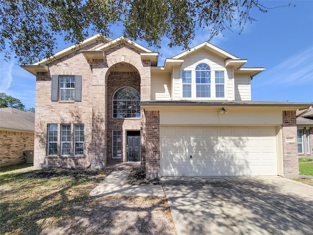 traditional home with an attached garage, concrete driveway, and brick siding