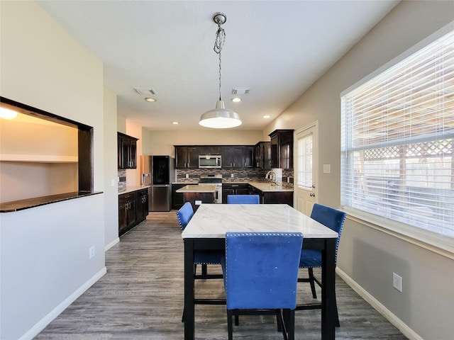 dining space featuring visible vents, baseboards, and wood finished floors