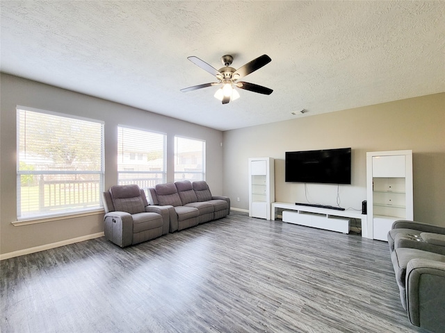 living room featuring visible vents, ceiling fan, a textured ceiling, and wood finished floors