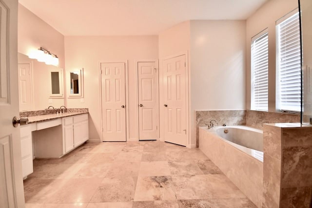 bathroom with a garden tub and vanity