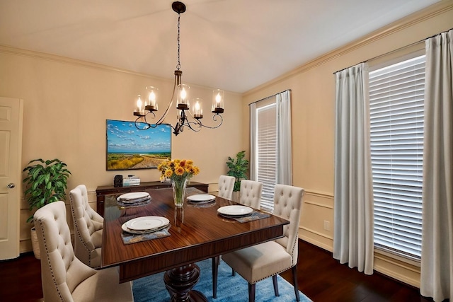 dining room with wainscoting, ornamental molding, a notable chandelier, and wood finished floors