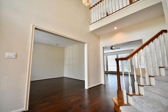 foyer entrance featuring stairs, a high ceiling, wood finished floors, and baseboards