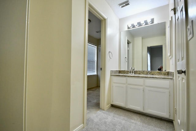 bathroom featuring baseboards, visible vents, and vanity