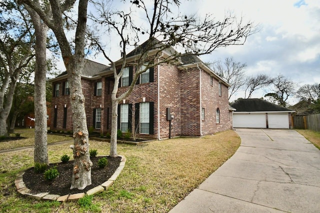 view of front of house featuring a garage, a front yard, brick siding, and an outdoor structure