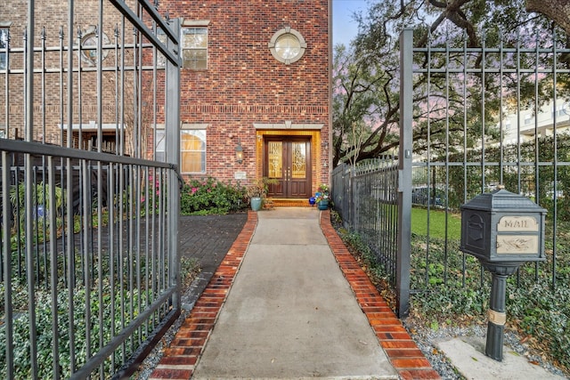 view of exterior entry with brick siding and fence