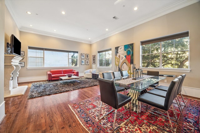 dining area featuring recessed lighting, a fireplace, wood finished floors, baseboards, and crown molding