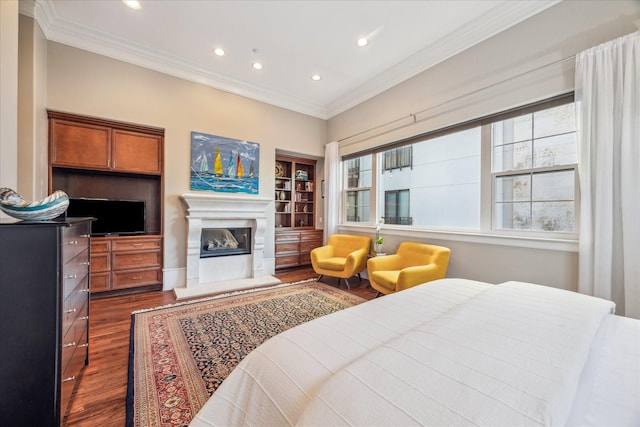 bedroom with dark wood-style floors, multiple windows, crown molding, and a glass covered fireplace