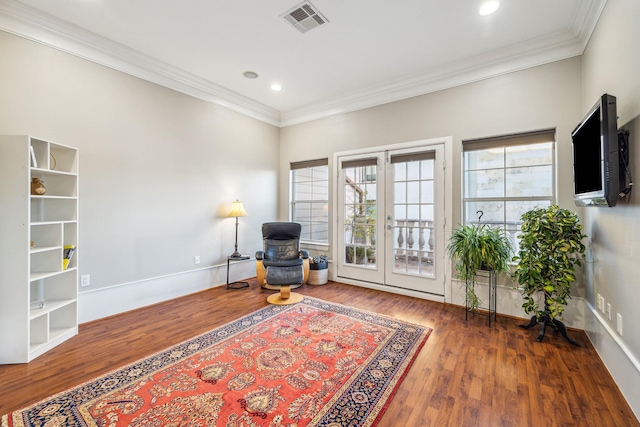 living area featuring french doors, visible vents, crown molding, and wood finished floors