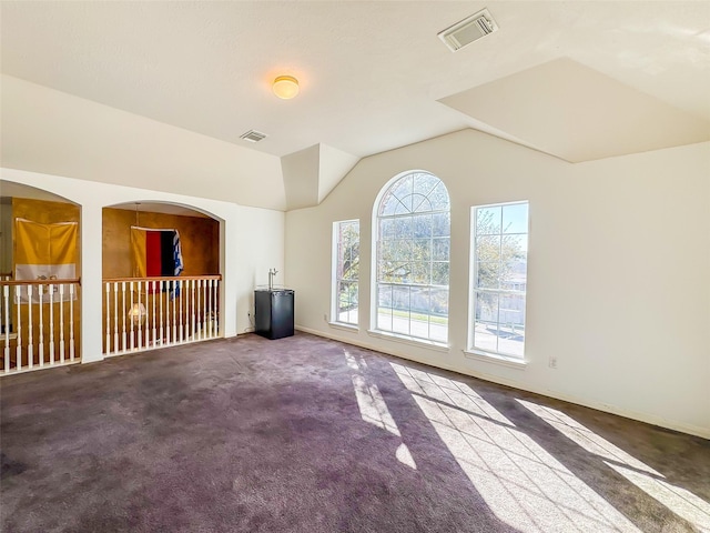 unfurnished living room featuring lofted ceiling, baseboards, visible vents, and carpet flooring