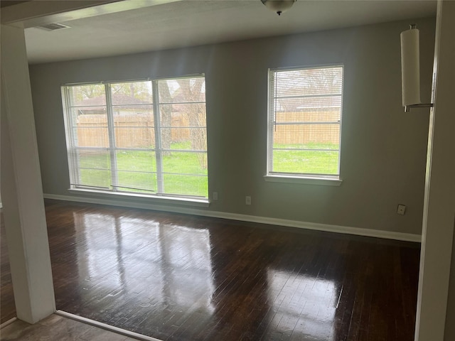 empty room with hardwood / wood-style floors and baseboards