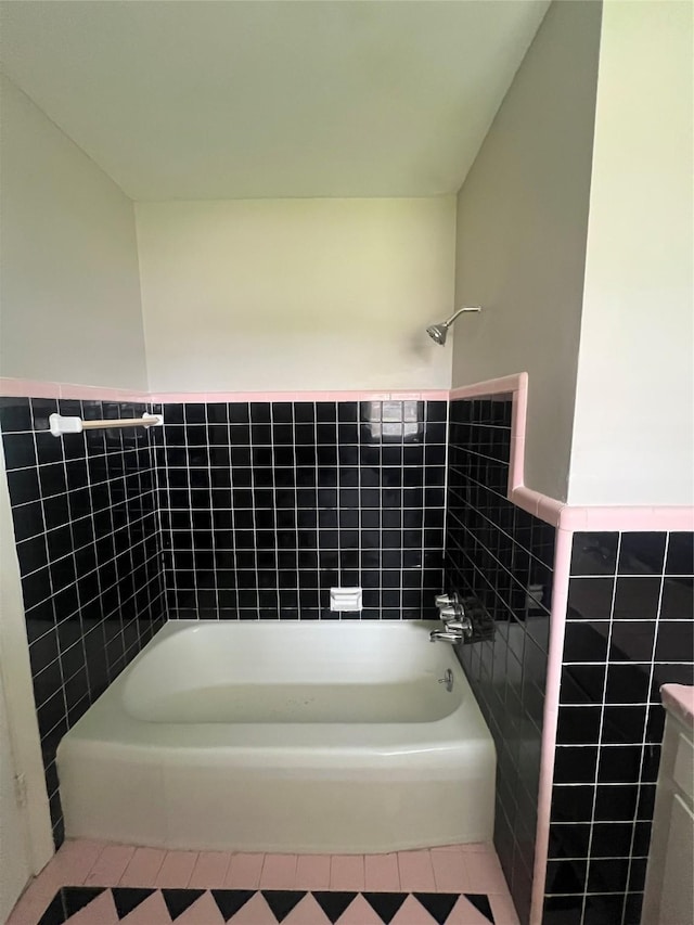 full bath featuring  shower combination, a wainscoted wall, tile walls, and tile patterned floors